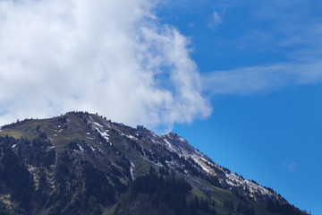 swiss mountain peak with blue sky and clouds.