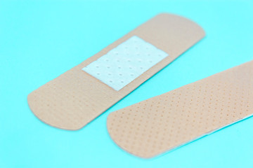 skin color medicine adhesive healing bandage layout on blue background. medical aid healing patch concept