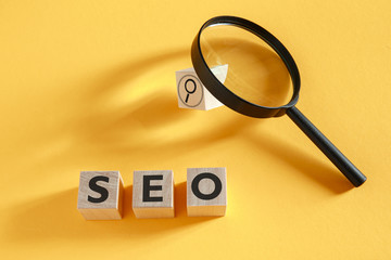 SEO search engine optimization concept. Wooden cubes with the abbreviation SEO on a yellow...