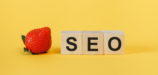 SEO search engine optimization concept. Wooden cubes with the abbreviation SEO on a yellow...