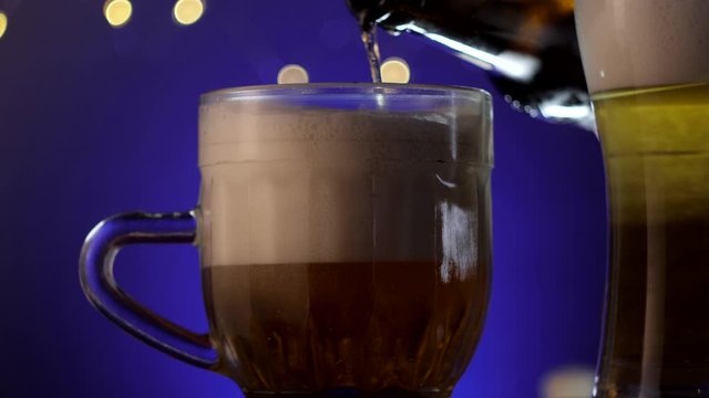 Filling mug of lager cold beer with huge beer foam from the bottle