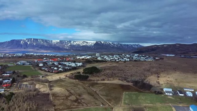Aerial of Mosfellsbaer, Iceland with Esjan mountain in the background. Track forward.