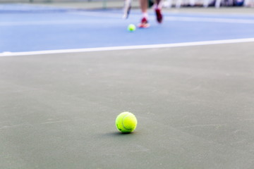 close up tennis ball in court and blurred player in tournament .