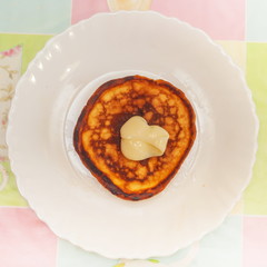 Pancakes with condensed milk on a white plate