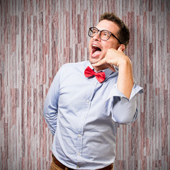 Man wearing a red bow tie. Doing a phone gesture.