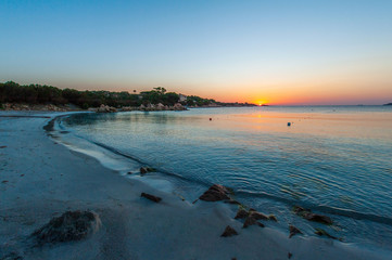 A landscape with the beautiful colors of sunrise on a summer vacation day with the deserted beach without people, in Sardinia Italy
