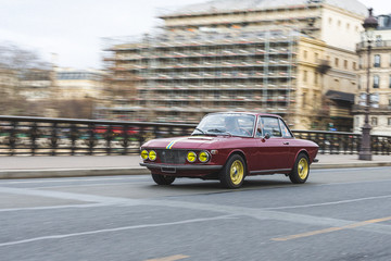 old vintage rally car, a classic perfectly preserved and restored prowling the streets of the city center of Paris
