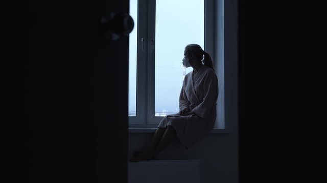 Girl sitting on the background of a window