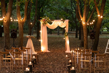 Wedding arch in the woods with light bulbs. Beautiful wedding rustic in the forest. Seats for...