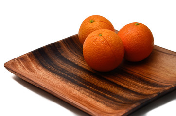 Oranges on a wooden plate