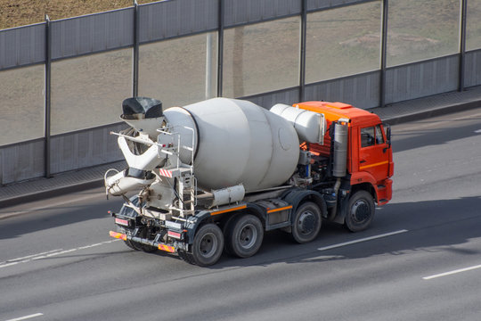 Concrete mixer truck rides on city highway.