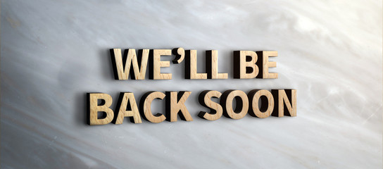 we will be back soon wood sign on marble wall.business under construction concept.3d rendering text