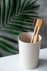 Eco-friendly bamboo toothbrushes in glass. Natural wooden oral hygiene accessories. Zero waste, plastic free, sustainable lifestyle concept