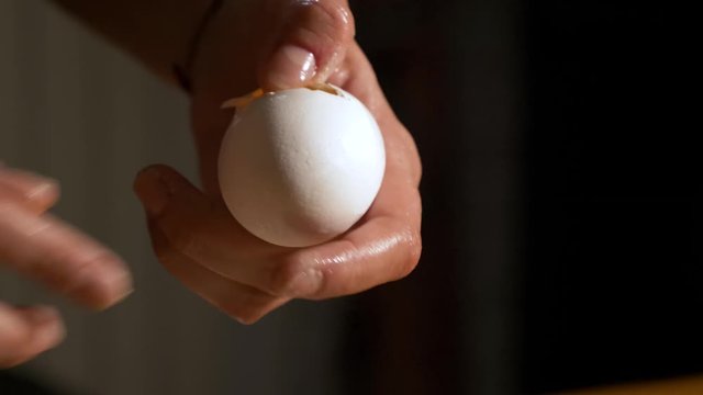 4K close up slow motion shot craked white fresh egg with a silver spoon