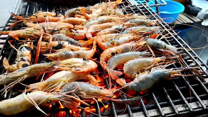 Fresh Shrimps or Prawns grilled on charcoal grill. Seafood barbecue party concept.