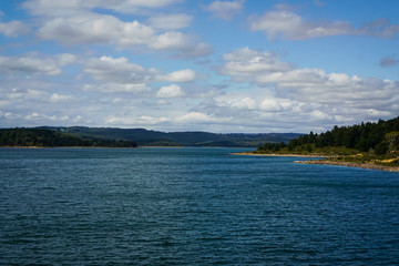 Lake with blue water under blue sky with few clouds