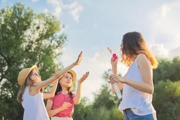 Obraz premium Children three girls playing with soap bubbles
