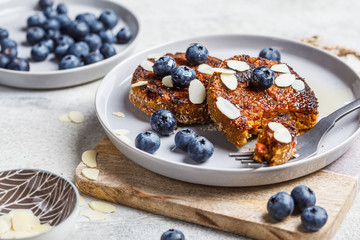 Tofu pancakes with blueberries and honey on gray plate. Healthy vegan food concept.