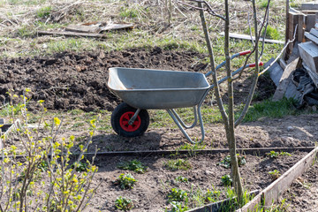 An empty construction car is standing in the garden.