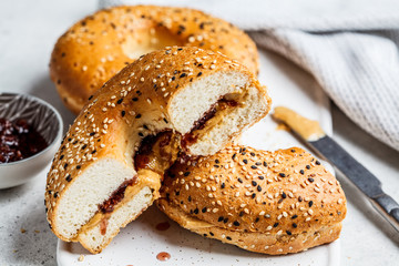 Bagels with peanut butter and berry jam on white board. Vegan food concept.