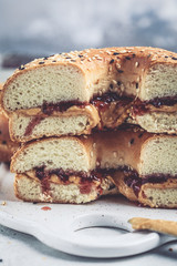 Bagels with peanut butter and berry jam on white board. Vegan food concept.