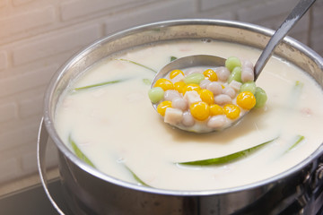 Thai sweetmeat call Bualoy balls in dippers with hot coconut milk in a pot and leaf pandan increase delicious