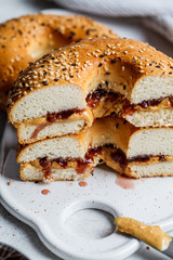 Bagels with peanut butter and berry jam on white board. Vegan food concept.
