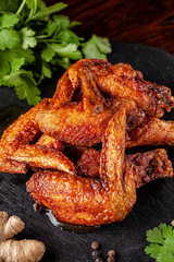 American cuisine. Fried chicken wings glazed in marinated with ginger and garlic on a black background. background image, copy space text.