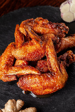 American cuisine. Fried chicken wings glazed in marinated with ginger and garlic on a black background. background image, copy space text.