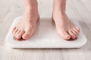 Bare feet stand on smart scales that makes bioelectric impedance analysis, BIA, body fat measurement.