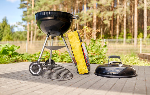 bbq and grilling concept - grill brazier and bag of charcoal outdoors