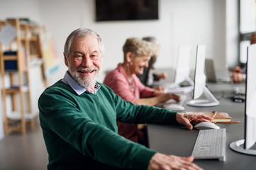Portrait of senior man attending computer and technology education class.