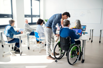 Senior man in wheelchair attending computer and technology education class.