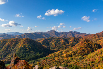 Fototapeta na wymiar 札幌市・定山渓近くの八剣山・山頂から眺める色とりどりの紅葉と青空
