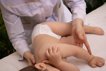 Fototapeta na wymiar baby massage in spa salon, neck and spine treatment