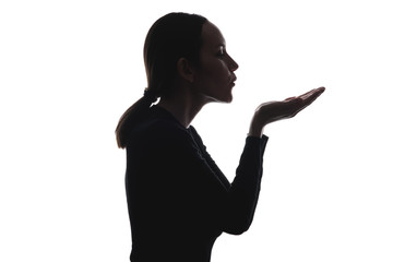 black and white image of woman's silhouette sends air kiss