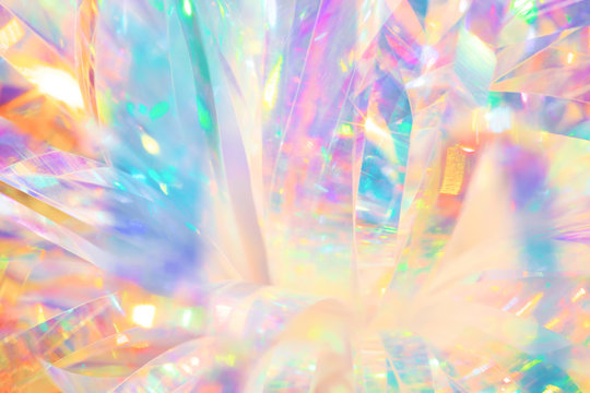 Festive cheerful abstract image texture of holographic foil ribbon in candy colors with sparkling light reflections