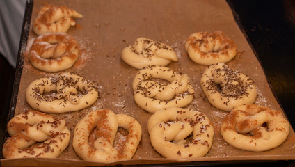 Top view of a croissant bagel prepared for baking sprinkled with sugar lying on parchment baking paper covered with flour. Sweet Bagel.