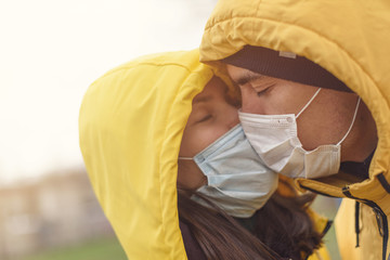 kissing couple in medical mask, love in quarantine time , distance concept
