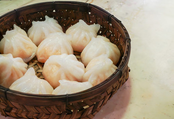 Homemade Chinese shrimp dumplings in dim sum bamboo basket on marble table background ,minimal and healthy food concept , with copy space