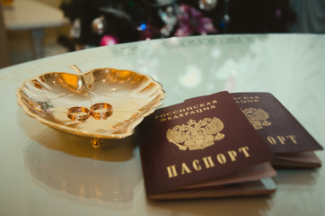 Wedding rings lie on a beautiful bouquet as bridal accessories
