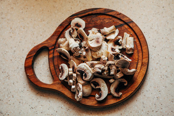 Sliced champignons on a cutting board. View from above.