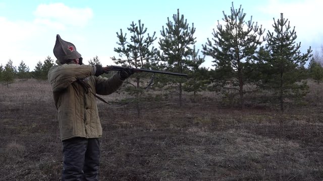 Man hunter soldier Red Army the forest field shoots firing shotgun, double gun
