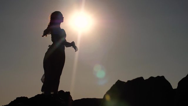 Woman holds out her hands to the sun
