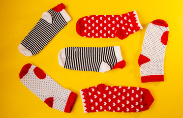 three pairs of bright women's socks with hearts on a yellow background