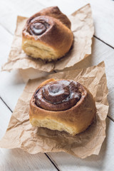 Cinnamon rolls closeup over a white rustic wooden table.