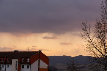 Sunrise and sunset, beautiful clouds over the meadow, hills and buildings in the town. Slovakia