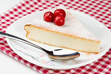 Piece of cheesecakeon on red-white napkin