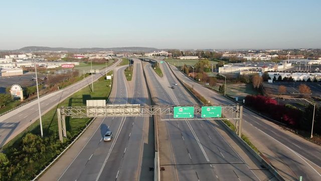 Wide angle high aerial of empty highway, expressway, roadway, intersection, extremely light traffic during COVID coronavirus shutdown