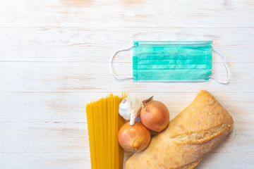 Donations food, vegetables, pasta, bread, and protective face mask wooden background